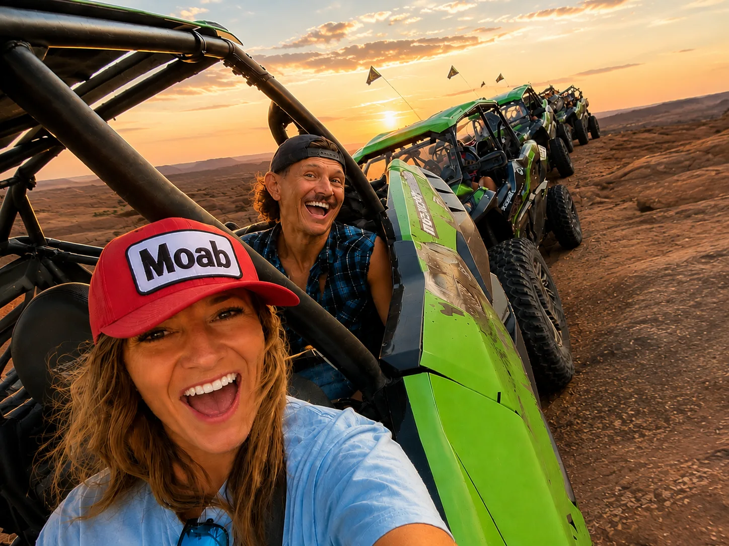 Riders smiling inside a green UTV with red rock scenery behind them
