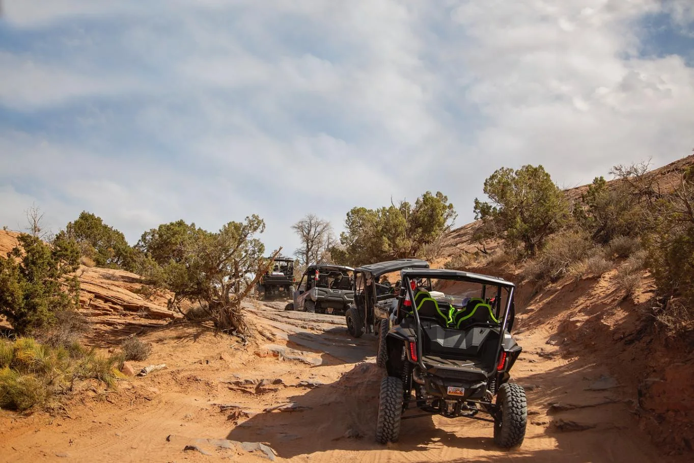 UTV following a sandy track between sandstone and shrubs