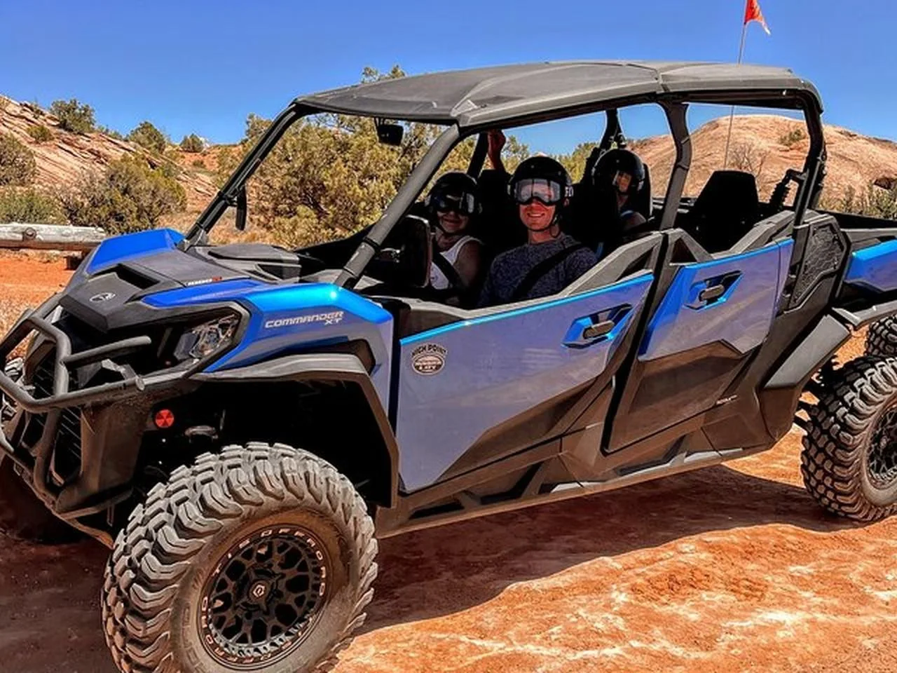 Riders in a blue UTV on the slickrock