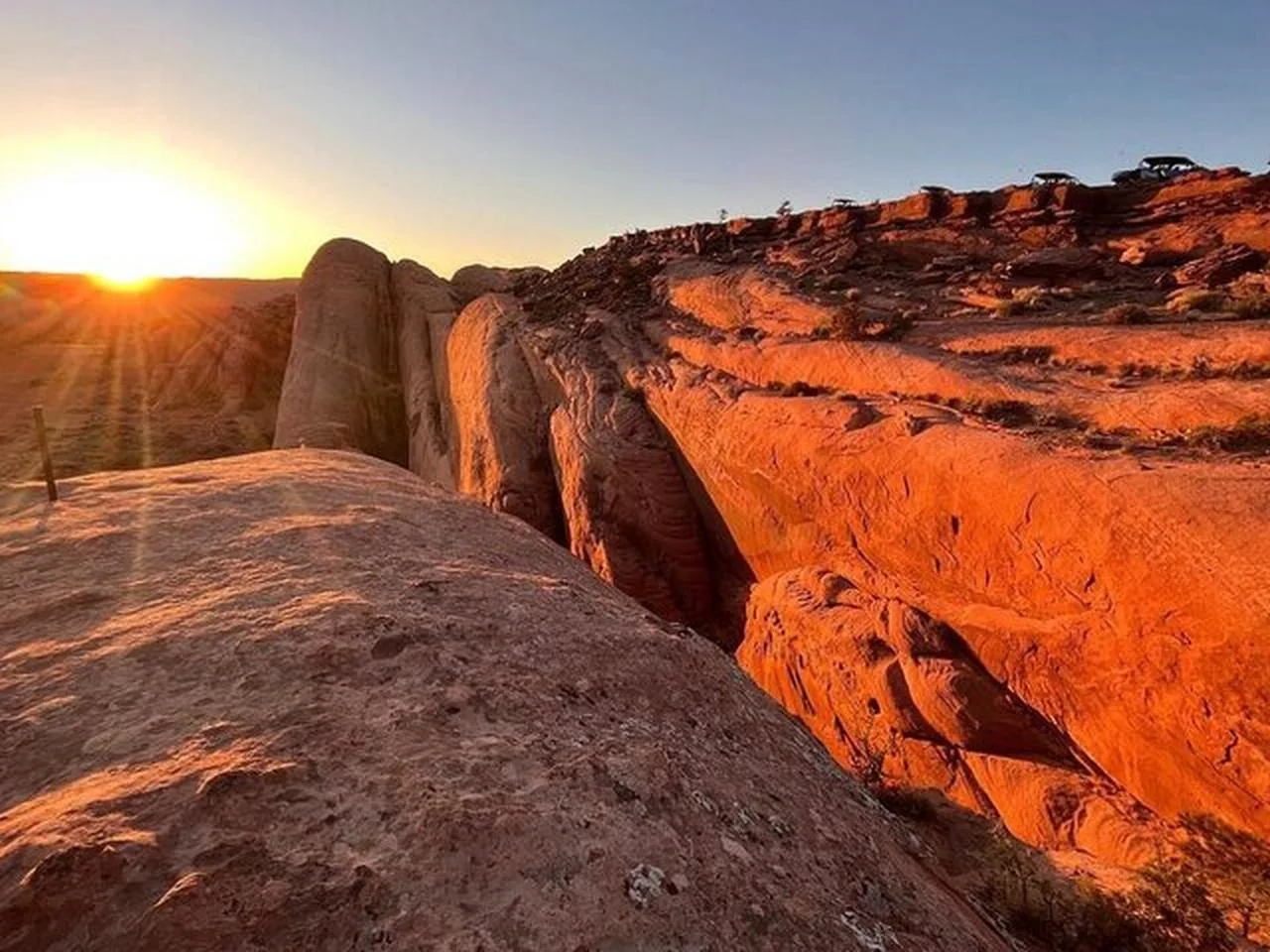 Sun setting beyond a narrow sandstone ridge